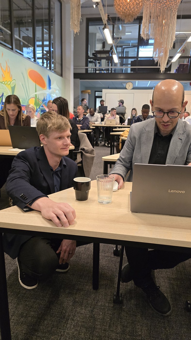 Jimmy Waern hjälper en deltagare vid datorn under en workshop